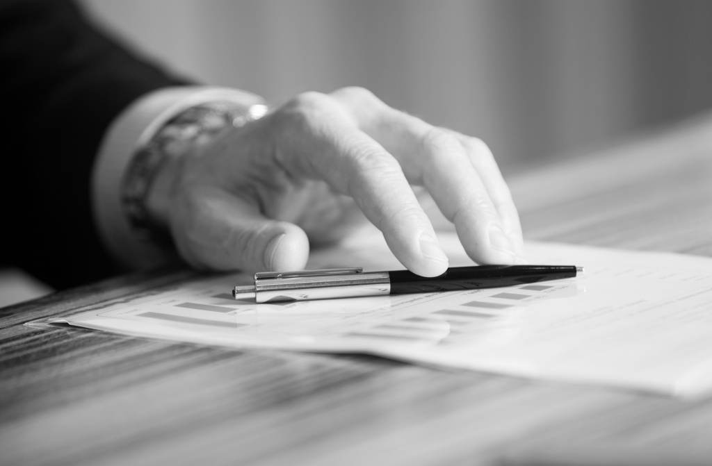man-s-hands-holding-a-black-pen-in-both-arms-in-a-thinking-gesture-during-a-meeting-or-negotiation.jpg