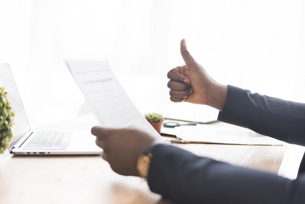 businessman-with-paper-gesturing-thumb-up.jpg